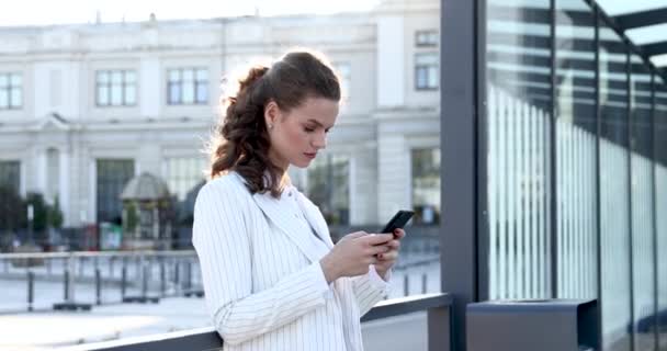 Zakelijke vrouw typt berichten op mobiele telefoon buiten — Stockvideo