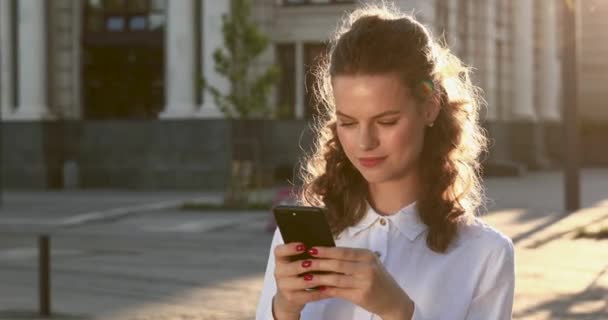 Senhora alegre desfrutando de tempo livre com celular no ar fresco — Vídeo de Stock