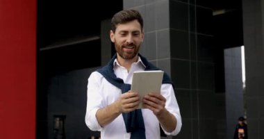 Dijital tabletteki video görüşmesi sırasında dışarıda duran sakallı başarılı bir iş adamı. Modern teknoloji ve çevrimiçi iletişim kavramı.