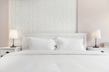 Pembe duvar kağıdıyla rahat beyaz yatak 