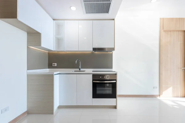 Apartmanda temiz beyaz bir mutfak köşesi.