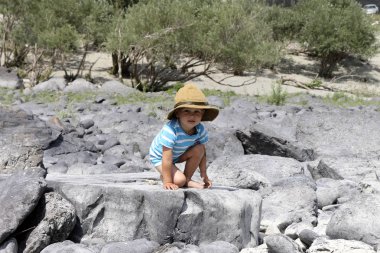 taşlar arasında bir kovboy şapkalı çocuk