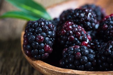 BlackBerry çilek makro. Ahşap bir tabak içinde taze böğürtlen