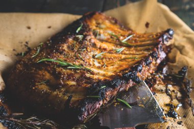 Bir ahşap masa ve balta üzerinde fırında kaburga