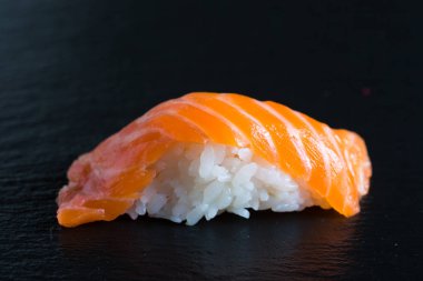 Suşi ve karanlık bir arka plan üzerinde rulo çeşitli