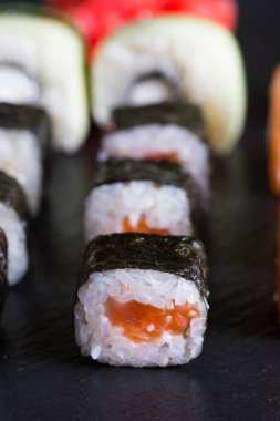 Suşi ve karanlık bir arka plan üzerinde rulo çeşitli