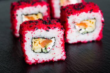 Suşi ve karanlık bir arka plan üzerinde rulo çeşitli