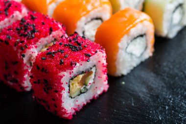 Suşi ve karanlık bir arka plan üzerinde rulo çeşitli