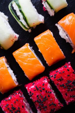 Suşi ve karanlık bir arka plan üzerinde rulo çeşitli