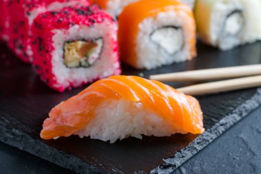 Suşi ve karanlık bir arka plan üzerinde rulo çeşitli