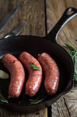 Sosis otlar ve baharatlar ile bir tavada kavurma