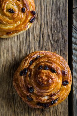 Ahşap bir masa üzerine üzümlü taze çörek