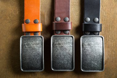 Deri kemerler ahşap arka plan üzerinde büyük bir toka ile