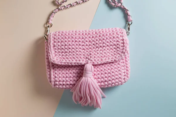Handmade knitted bags on a colored background