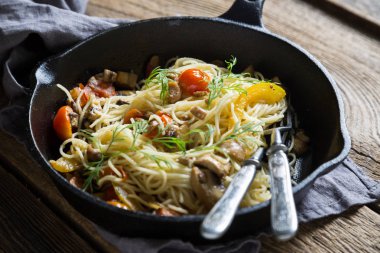 Bir tava içinde mantar ve domates ile spagetti