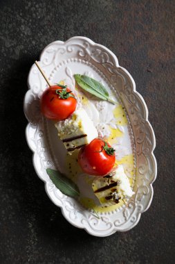 Bir şiş üzerinde kızarmış peynir ve domates