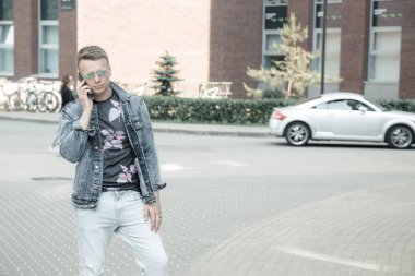 Sokakta akıllı telefonlu genç bir adam.