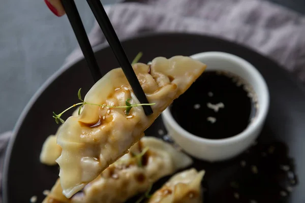 Koyu bir masada soya sosuyla doldurulmuş Wonton.