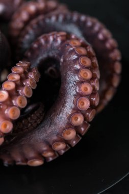 Koyu arkaplanda bir tabakta ahtapot