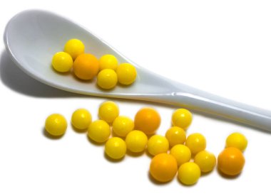 Sarı vitamin ve porselen kaşık kompozisyon