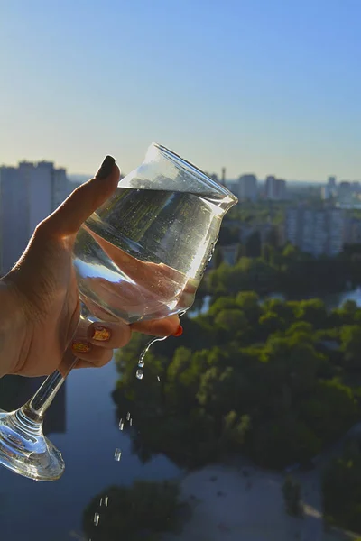 Water in a glass with a city view