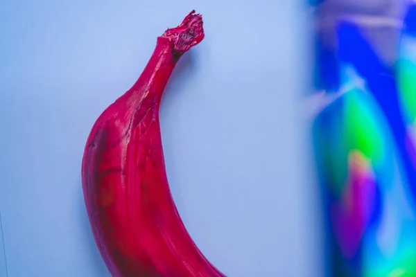 Multicolored bananas. A red banana. White banana. Pink background.