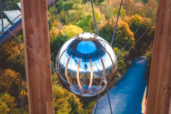 Observation deck. Spiral staircase. Modern architecture. Metal ball on the ropes. Mirror ball. Autumn forest. Beautiful view. Height. The mountains. Germany. Journey. Ball for balance Wooden beams. Metal cables. Tower.