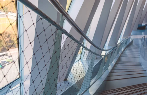 Modern architecture. Lines in construction. White interior. Design solution. Big windows. Glass. Beams. Grid of ropes. Stairs. The museum.