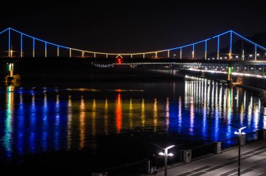 Renkli ışıklar ve yansıma su, Kiev (Kiev) Ukrayna'nın başkenti gece Avrupa şehirde. Dnieper Nehri ve görünümü aydınlatma akşam nehir İstasyonu yaya köprüsü
