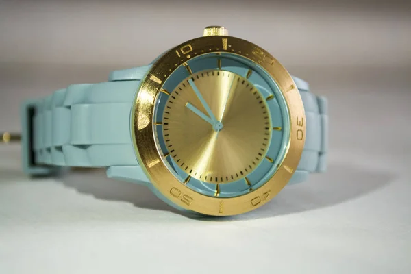 Muñequeras reloj con el dial de oro y una tanga de goma azul . — Foto de Stock