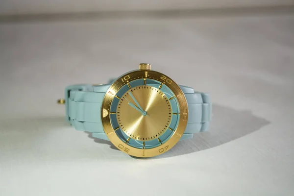 Muñequeras reloj con el dial de oro y una tanga de goma azul . —  Fotos de Stock