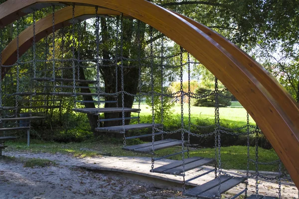 Çocuk etkileşimli Bahçesi. Ahşap bir kemer ile bir kısa merdivenin üzerinde zincirleri dengeleme için. Çocuklar için bir oyun. 