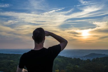 Turist ve Almanya botanik, güzel bir yer. Sonbahar sezonu. Yürü. Adam bir manzaraya günbatımında sınırsız yoğun orman ve tepelik alanı ile görünüyor. Mavi gökyüzü.