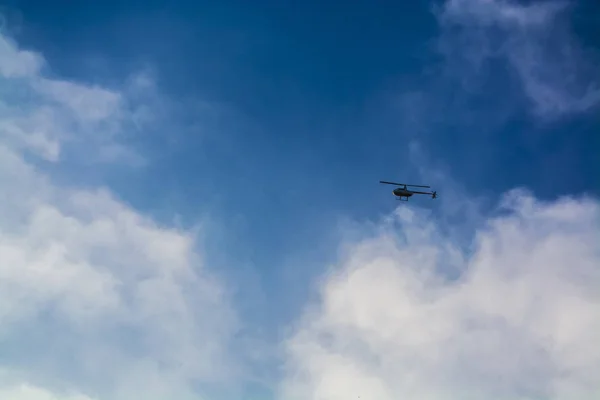 Sıcak yaz aylarında beyaz bulutlar ile mavi gökyüzü. Son derece baş üzerinde helikopter uçuş. — Stok fotoğraf