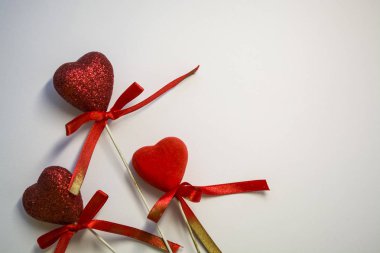 Beyaz arka plan. Kutlama. St. Valentine's Day. Kırmızı kalpler payetler ve yay. Evin için bir dekor. Aşk.