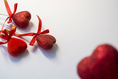 Beyaz arka plan. Kutlama. St. Valentine's Day. Kırmızı kalpler payetler ve yay. Evin için bir dekor. Aşk.