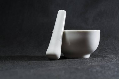 Beyaz harç havaneli Porselen takımlar ile. Baharatlar kırma için içme bir kase. Siyah arka plan. Mutfak eşyaları. Tesisat.