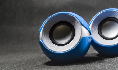 Taşınabilir küçük hoparlörler müzik için. Plastik. Siyah arka plan. Mavi ve beyaz renkler. Yuvarlak şekli. Modern ekipman. Teknolojileri.