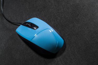 Küçük bilgisayar fare plastik. Mavi renk. Siyah arka plan. Siyah tel. Bir yazıt için boş bir alan. Elektronik.