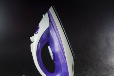 Elektrik demir beyaz ve mor renk. Bir tek sesli siyah arka plan üzerine. Bir yazıt için boş bir alan. Modern tasarım.