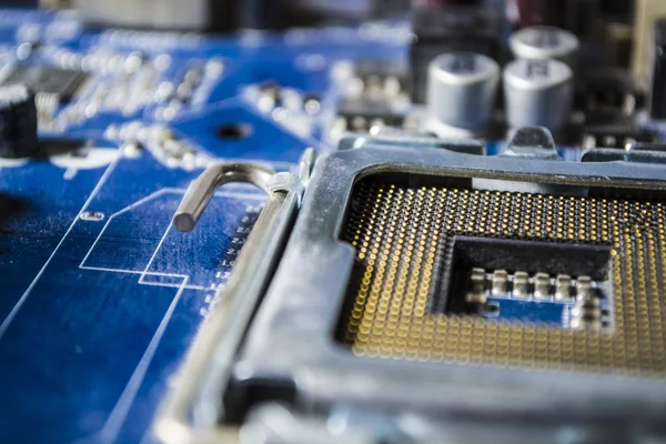 The old and dusty motherboard from the computer. Blue color. Switches. Details from the personal computer. Repair. Dust.