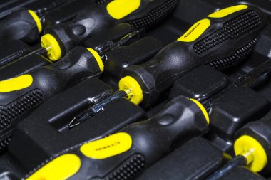 Büyük alet çantası siyah ve sarı renk bir kutu evi. Düz burun pense, vida sürücüleri, ileti örneği bıçak ve kerpeten. Onarım.