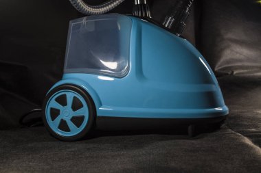Kompakt, küçük elektrikli süpürge mavi renk ev için. Temizlik. Ekipman. Modern teknolojiler. Siyah arka plan.
