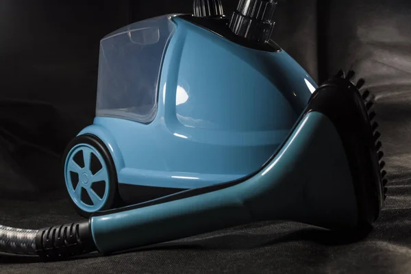 Le petit aspirateur compact pour la maison de couleur bleue. Nettoyage. Du matériel. Les technologies modernes. Fond noir . — Photo