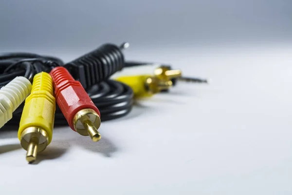 Hank of cables with multi-colored plugs a tulip. Black cord. White monophonic background. Multimedia switch. — Stock Photo, Image