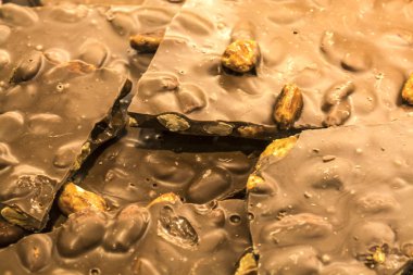 Kırık fayans süpermarkette bütün fındık ile sütlü çikolata. Doku veya arka plan. Tatlılar. Doğal ürün. Yararlı öğeleri.