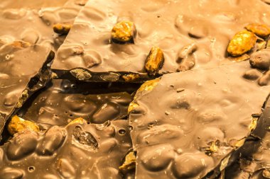 Kırık fayans süpermarkette bütün fındık ile sütlü çikolata. Doku veya arka plan. Tatlılar. Doğal ürün. Yararlı öğeleri.