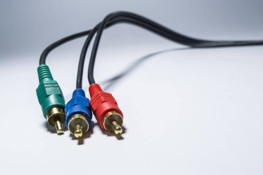 Beyaz arka plan. Birkaç siyah Telleri fişler ile. TV kablosu, multimedya. Lale. Farklı renk. Elektronik.