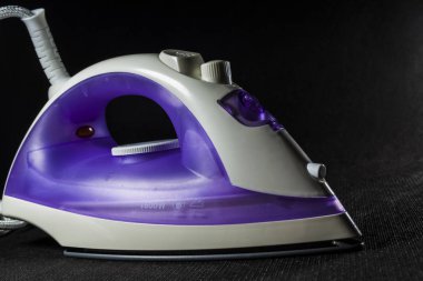 Elektrik Menekşe demir beyaz renk ile. Modern küçük ev aletleri ev için. Ütü. Siyah arka plan.