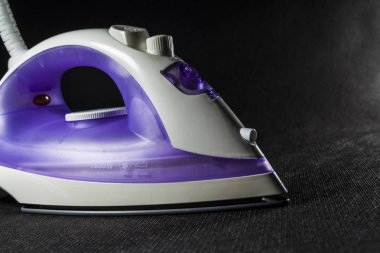 Elektrik Menekşe demir beyaz renk ile. Modern küçük ev aletleri ev için. Ütü. Siyah arka plan.